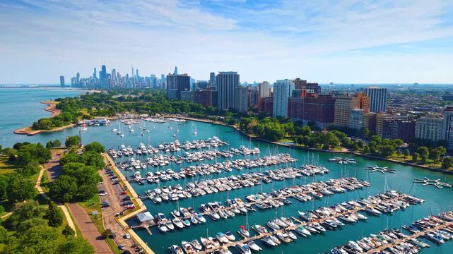 Multiple boats at the berths in the big harbor on Lake Michigan. Scenery of modern Chicago, Illinois, USA from drone.