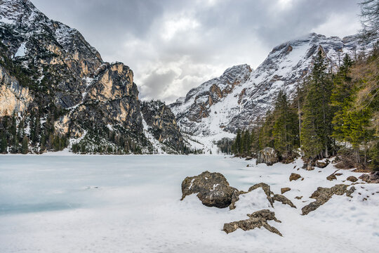 Lake Braies (Pragser See) in South Tyrol in winter, view of snowy mountain and Lake, Snow-covered Pragser Wildsee surrounded by steep, rocky mountains. 
