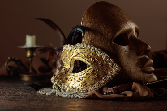 Golden carnival masks on a brown background.