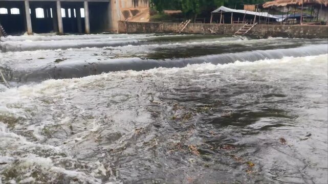 Low Angle View of Water Overflowing Concrete Weir and Dam Gate