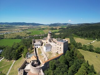 Zamek Lubowelski - Słowacja Pieknie położony zamek niedaleko gór, Tatr i Pienin, zdjęcie wykonane dronem z góry. Zamek, góry, przyroda, drzewa, dron, podróż © Konrad