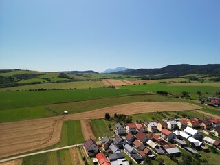 Słowacja - piękne pola z widokiem na góry Tatry, zdjęcie wykonae dronem. Pola, góry, Tatry, miasteczko, piękne miesjca © Konrad