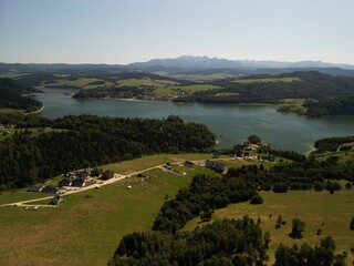 Jezioro Czorsztyńskie - Polska Piękne jezioro na pograniczu gór Pienin i Tatr, zdjęcie wykonane dronem. Lato, wiosna, jesień, jezioro, góry, pola, niebo ,zamek, plaża, piękne widoki. © Konrad