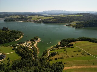 Jezioro Czorsztyńskie - Polska Piękne jezioro na pograniczu gór Pienin i Tatr, zdjęcie wykonane dronem. Lato, wiosna, jesień, jezioro, góry, pola, niebo ,zamek, plaża, piękne widoki. © Konrad