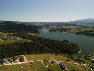 Jezioro Czorsztyńskie - Polska Piękne jezioro na pograniczu gór Pienin i Tatr, zdjęcie wykonane dronem. Lato, wiosna, jesień, jezioro, góry, pola, niebo ,zamek, plaża, piękne widoki. © Konrad