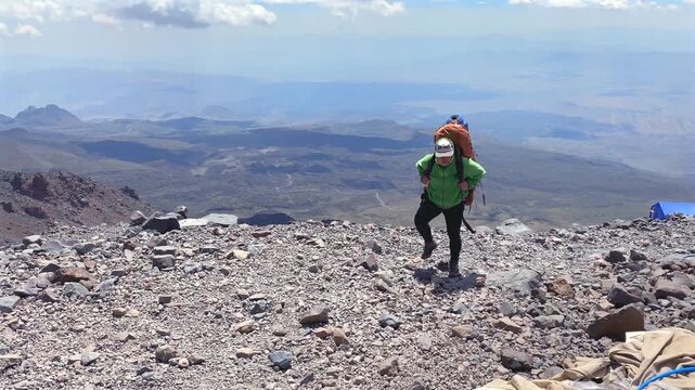 Man walking toward a tent at Mount Ararat high camp in Turkey, showing post-ascent recovery, expedition lodging, high-altitude trekking logistics, and mountain camp routine for climbers