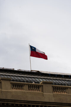 Flag of Chile draped over a historic building. Cloudy day. City of Santiago
