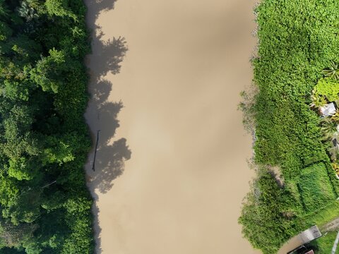 Aerial drone view of the Iracoubo River near the town of Iracoubo, French Guiana, surrounded by lush tropical vegetation.