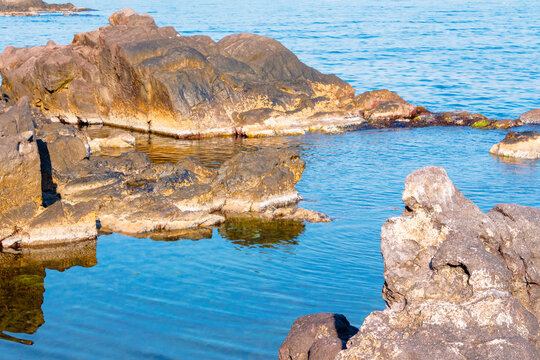 peaceful rock reflection in the sea water. calm summer vacation at the black sea. sunny weather