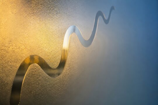 Metallic wave line on frosted glass abstract blue gold background