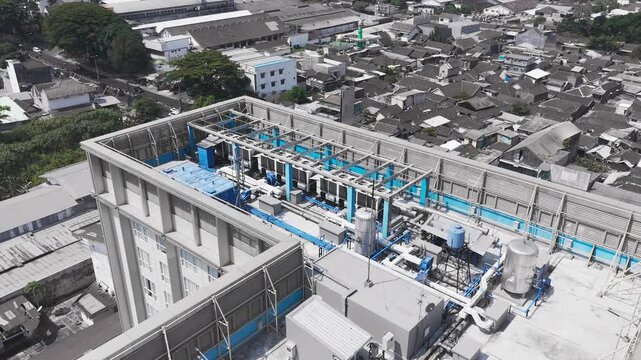 Aerial drone view of rooftop cooling infrastructure at a data center, featuring multiple industrial cooling units, ventilation fans, connected piping, and mechanical equipment supporting high-performa
