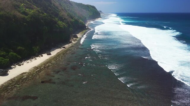 Scenic landscape with cliff coastline, beach and blue ocean with waves. Drone view