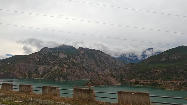 Coruh River stretches in wide roadside view through a rocky mountain valley near Artvin, Turkey, showing regional hydrology, scenic road travel, transport infrastructure, and nature tourism