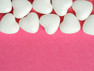 Fototapeta premium White Heart Candies Lined on Pink Background for Valentine Love and Romantic Sweet Concept