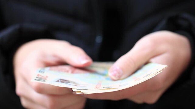 Hands counting euro banknotes for cash payment, personal finance and money management close up