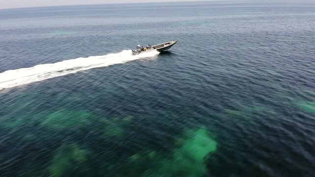 Aerial view of a smuggler boat sailing at high speed near the coast of Algeciras, Spain.