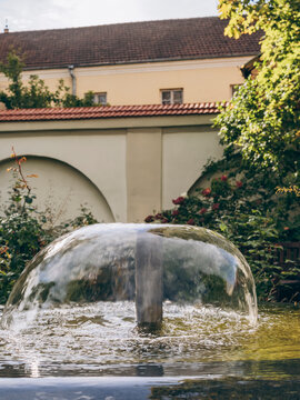 water fountain in a garden with arched walls and greenery