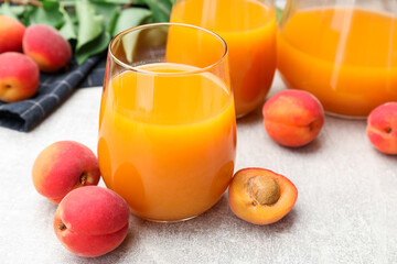 Apricot juice, fresh fruits and leaves on light table, closeup © New Africa