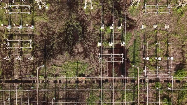 Electrical power substation with switchgear and pylons among greenery