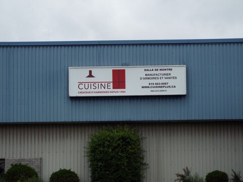 Gatineau, Quebec, Canada &ndash; June 28, 2026: A white "Cuisine Plus" business sign is mounted on the blue corrugated metal exterior wall of a commercial building on Bd Saint-Ren&eacute; E.