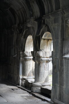 Stone interior of a historic Armenian monastery with narrow arched windows and medieval architecture.
