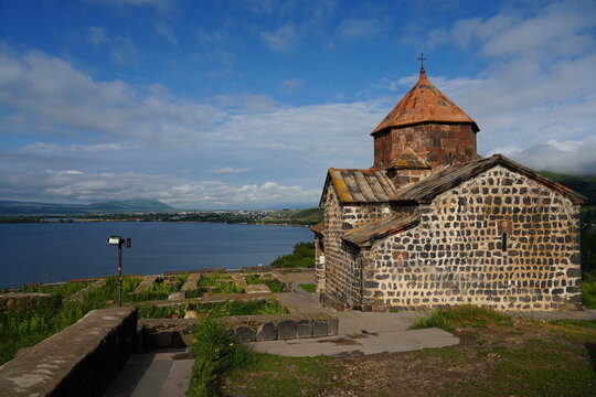 Sevanavank Monastery on the shores of Lake Sevan in Armenia, with blue water and mountains in the background.