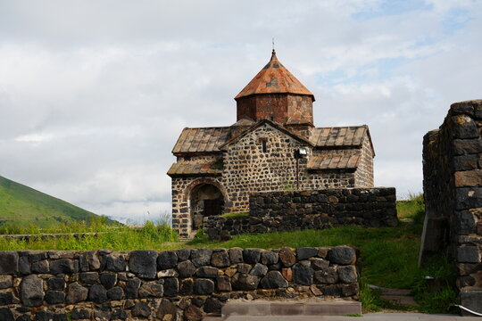 Sevanavank Monastery in Armenia with a historic stone church set against green hills and Lake Sevan.