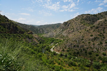 Fototapeta premium Dry Armenian mountain gorge with rugged rocky slopes and sparse vegetation. 