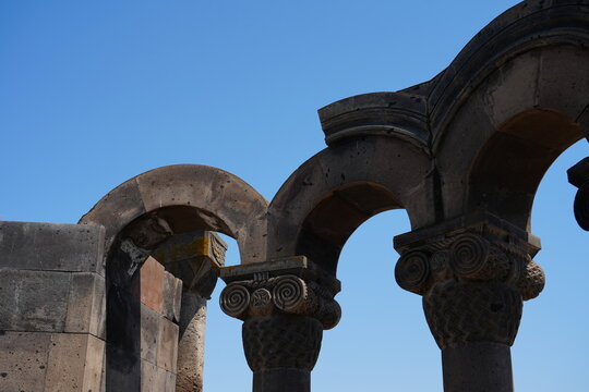 Architectural detail of the Zvartnots Cathedral in Vagharshapat, Armenia, with classical columns and landscaped surroundings.