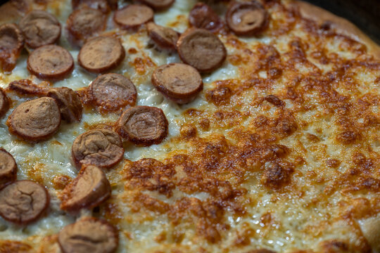 Homemade white pizza with sausage and cooked ham