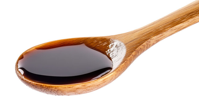 A wooden spoon containing dark liquid, such as soy sauce or balsamic vinegar, isolated on a black background, for food