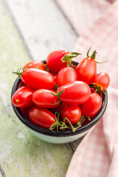 Fresh Cherry Tomatoes in Bowl on Rustic Table With Pink Cloth . Healthy Red Produce