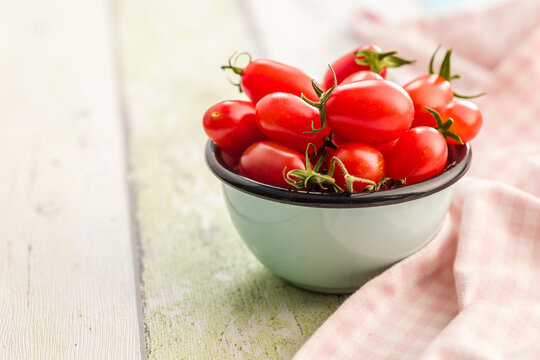 Fresh Cherry Tomatoes in Bowl on Rustic Table With Pink Cloth . Healthy Red Produce
