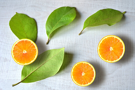 Fresh orange fruit with slices and leaf on white background