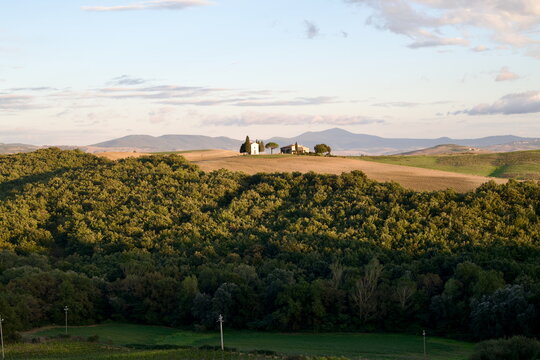 Panoramic landscape of Vitaleta Chapel on rolling hills in Val d'Orcia Tuscany Italy for travel website