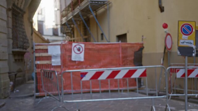 Construction site defocused alley background with scaffolding, orange netting and metal barriers for urban texture and blur; background backplate copyspace template.
