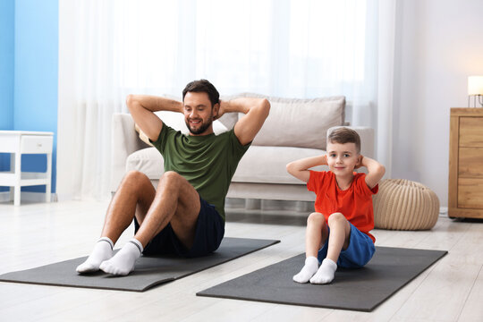 Father and his son doing exercise together at home