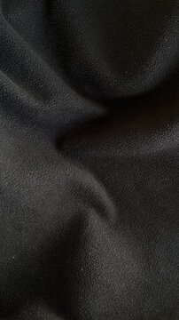 Black fabric texture with slow moving shadows and light