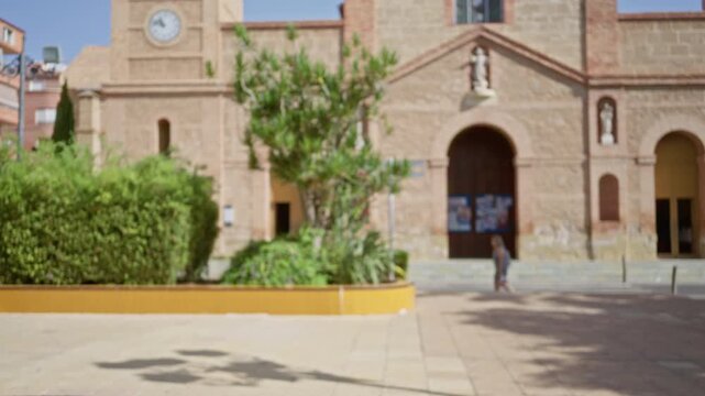 Soft blurred facade of a church with hedges and plaza in shallow bokeh background; backplate copyspace virtual calm.