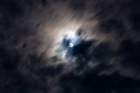 Full moon in the night sky with clouds