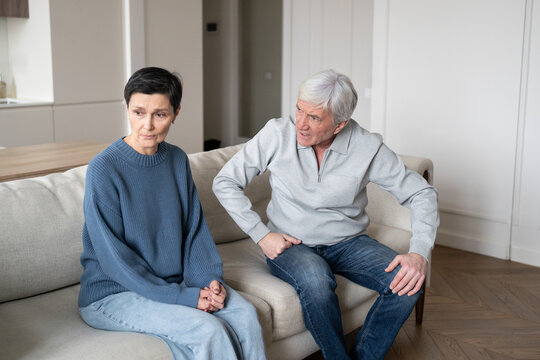 Angry elderly man shouting and blaming wife while she sits silently listening, senior couple facing domestic conflict. Narcissistic outbursts, emotional abuse, manipulative control. Toxic relations.