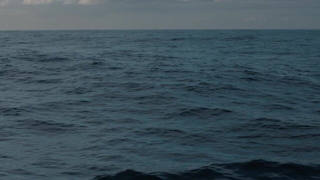 Open ocean with waves as seen from the moving sailing vessel