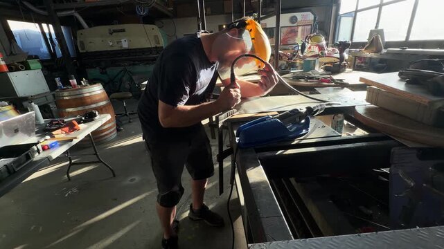 Artisan metalworker shaping metal in a sunny workshop