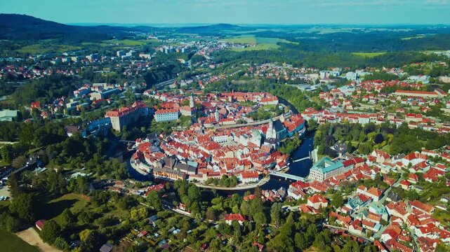 Aerial view of historic medieval town with red-tiled rooftops by a winding river