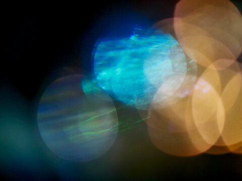 Abstract bokeh lights glow warmly in darkness. Soft orange tones create dreamy, atmospheric mood. Ideal for backgrounds, creative projects, or minimalist designs. Evokes calm, mystery