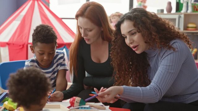 Woman guiding boy with pencil and pointing to xylophone and wooden blocks in a children's classroom playroom, toys on table; play based nurturing.
