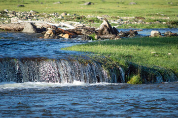 Small cascading waterfall with driftwood along the bank, Orkhon Valley, Mongolia © 由季 中山