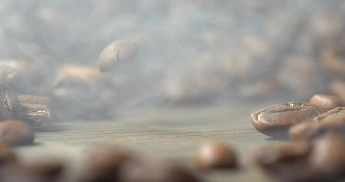 One roasted coffee bean falling onto wooden table in super slow motion
