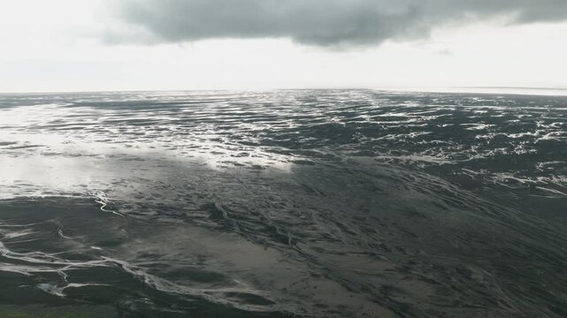 Black Sand Tidal Flat Aerial Under Cloudy Sky, Iceland