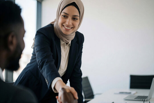 Businesswoman in a hijab shaking hands with a colleague